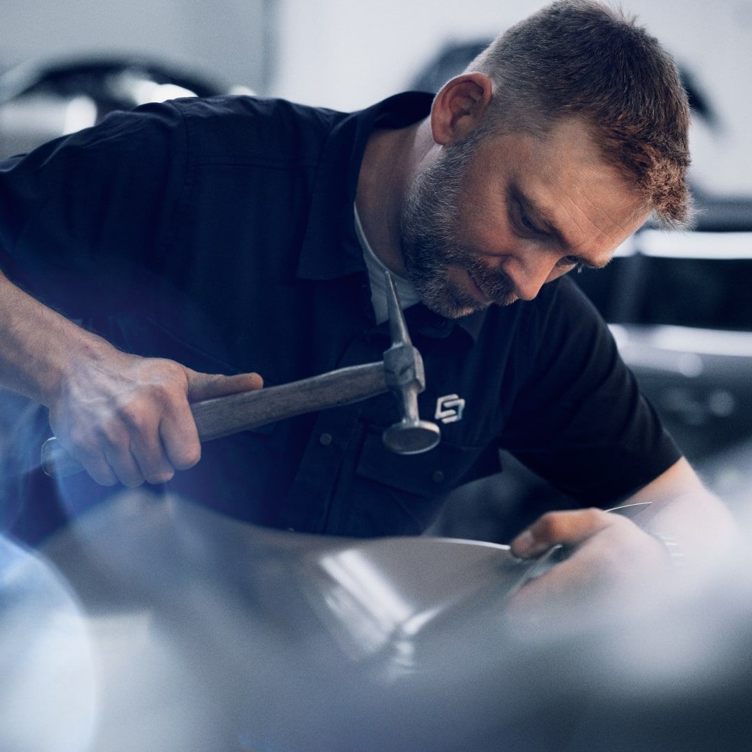 En man arbetar i bilverkstad