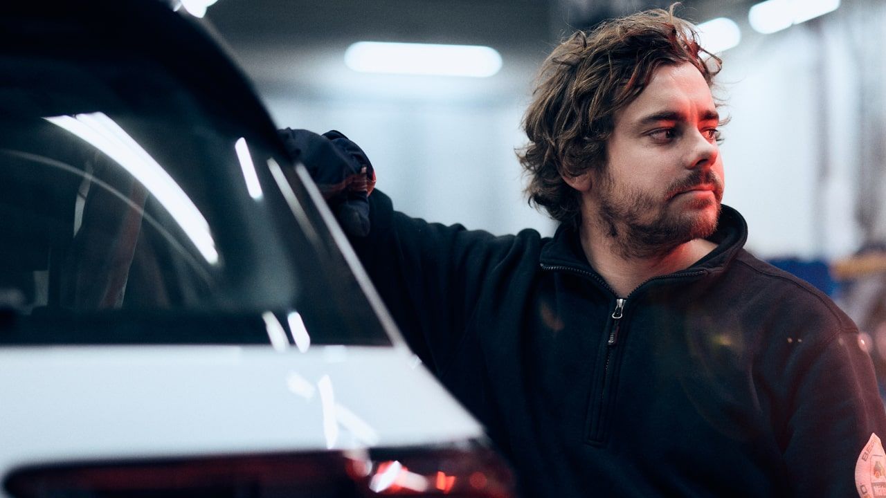 En man arbetar i bilverkstad