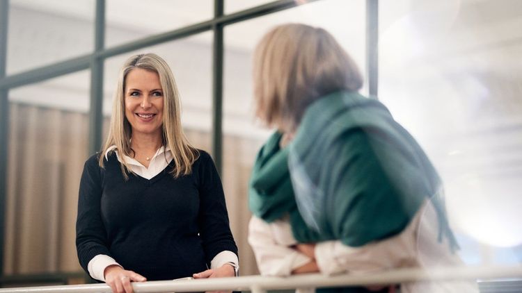 Två kvinnor i samtal på ett kontor